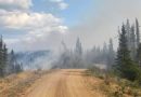 Dirt road with smoke in the distance.