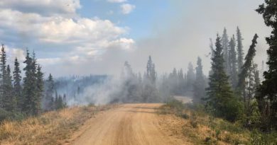 Dirt road with smoke in the distance.