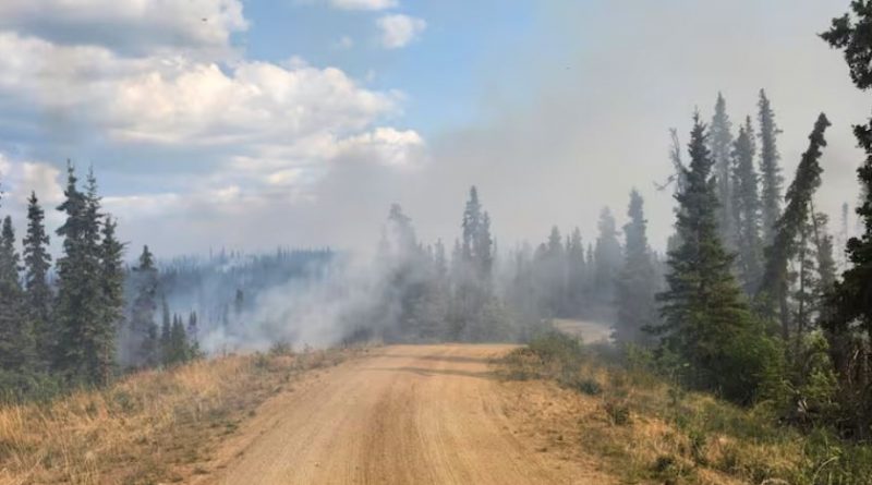 Dirt road with smoke in the distance.