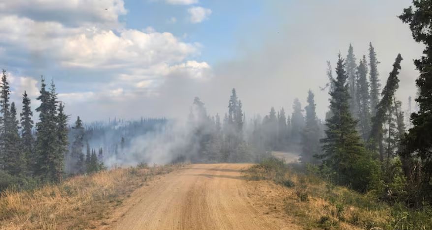 Dirt road with smoke in the distance.