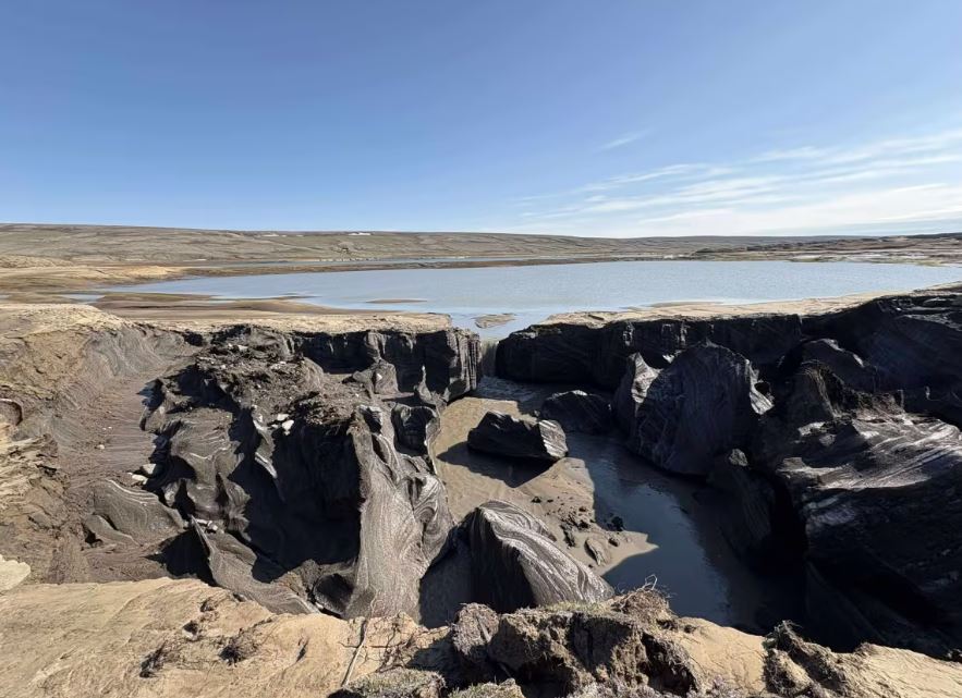 An eroded channel near a lake on the tundra.