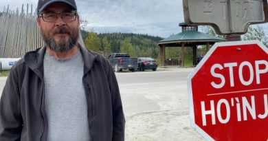 A man standing beside a stop sign. Tr'ondëk Hwëch'in Hähkè (Chief) Darren Taylor in 2024.