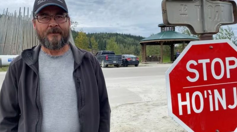 A man standing beside a stop sign. Tr'ondëk Hwëch'in Hähkè (Chief) Darren Taylor in 2024.