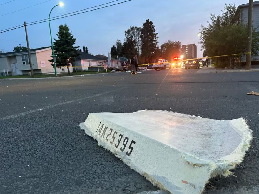 Debris on a road with caution tape in the background.
