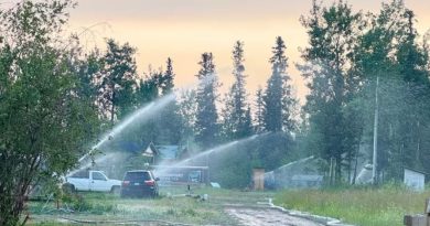Trucks are seen from afar hosing down some structures.