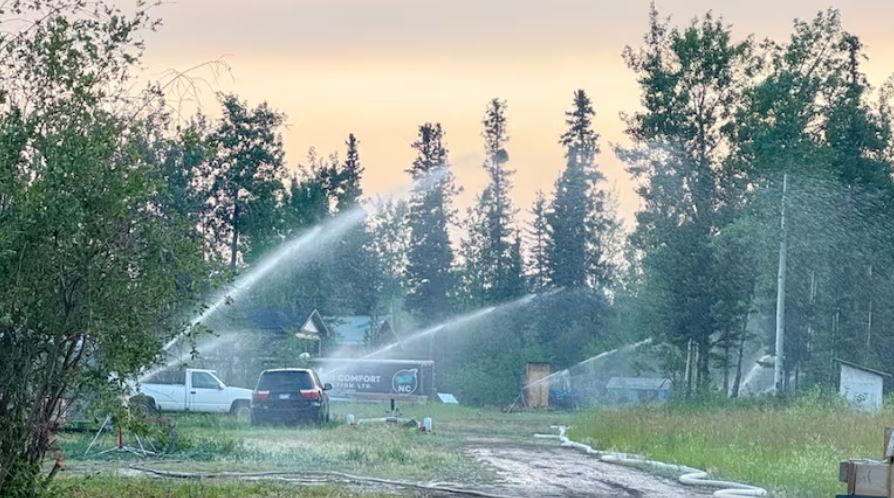 Trucks are seen from afar hosing down some structures.