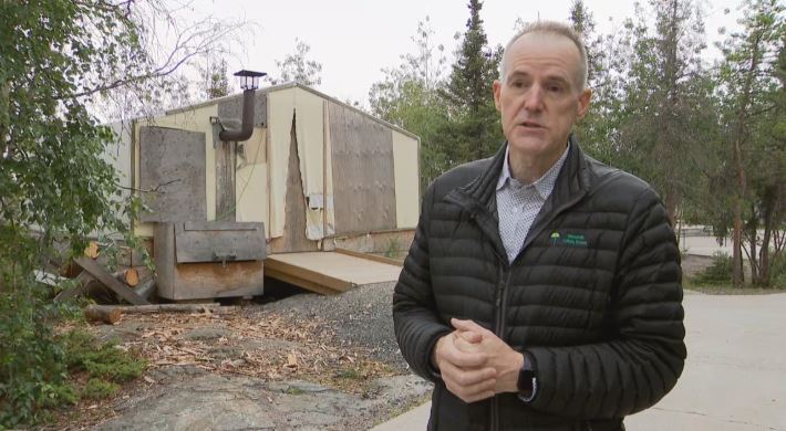 Principal Paul Kelly stands before a tent structure on the school grounds of Weledeh Catholic School. 