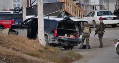 Men with guns and tactical gear stand outside.