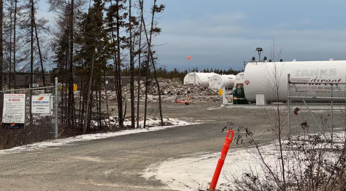 Excavated rocks near white fuel tanks