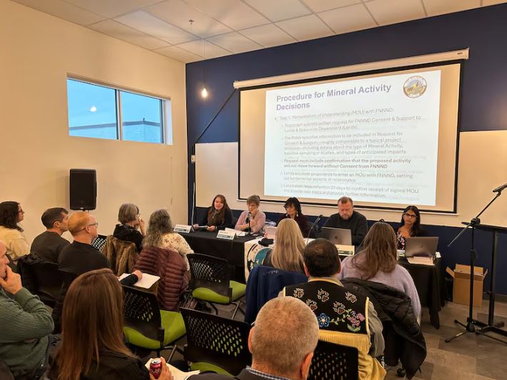 A panel speaks in front of an audience.