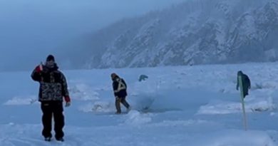 A group of people in snowsuits. One person is giving a thumbs up.