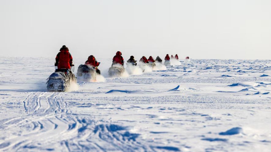 Canadian Rangers on Ski-Doo travelling across snow-covered land.