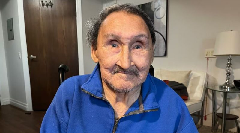 A man in a blue sweater sits for photo. John Amagoalik speaks with CBC Indigenous in Ottawa in April 2026.