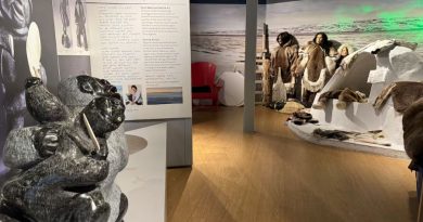 sculptures in the forefront, models of Inuit in parkas in the background