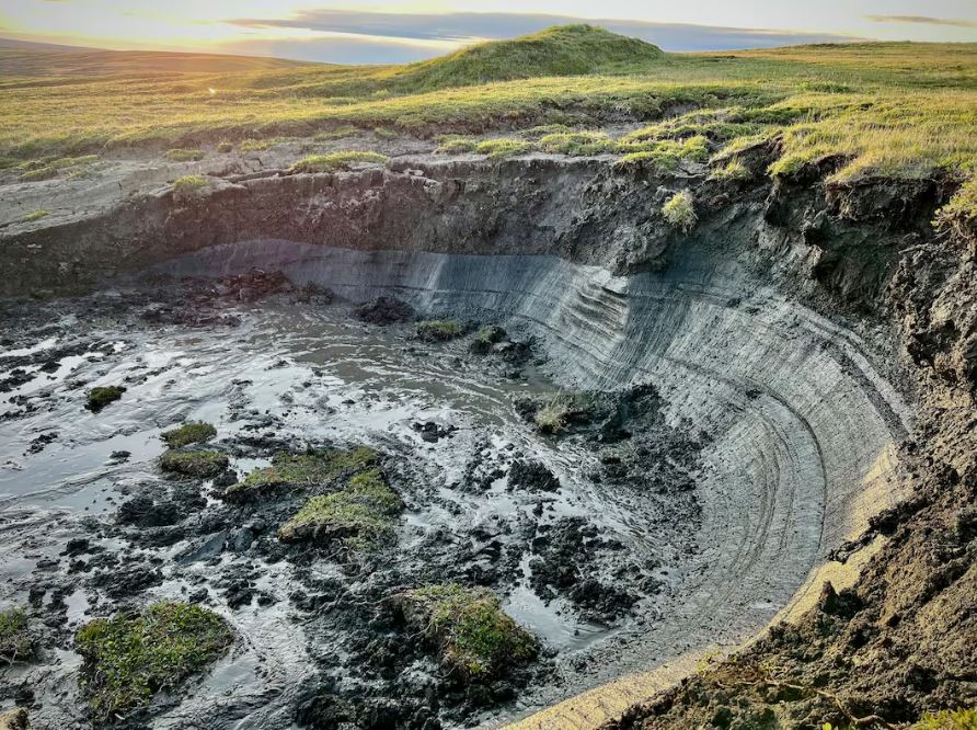 A sunken portion of land with a small cliff within a green landscape.