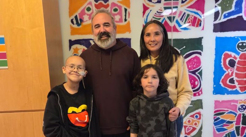 Chloe stands with her father, mother and younger brother.