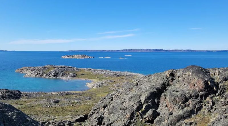 A rugged rocky coast line with blue ocean in the background with more rugged coast behind
