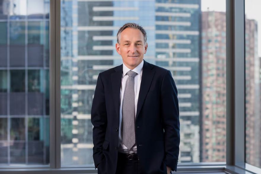 man in suit stands in front of office