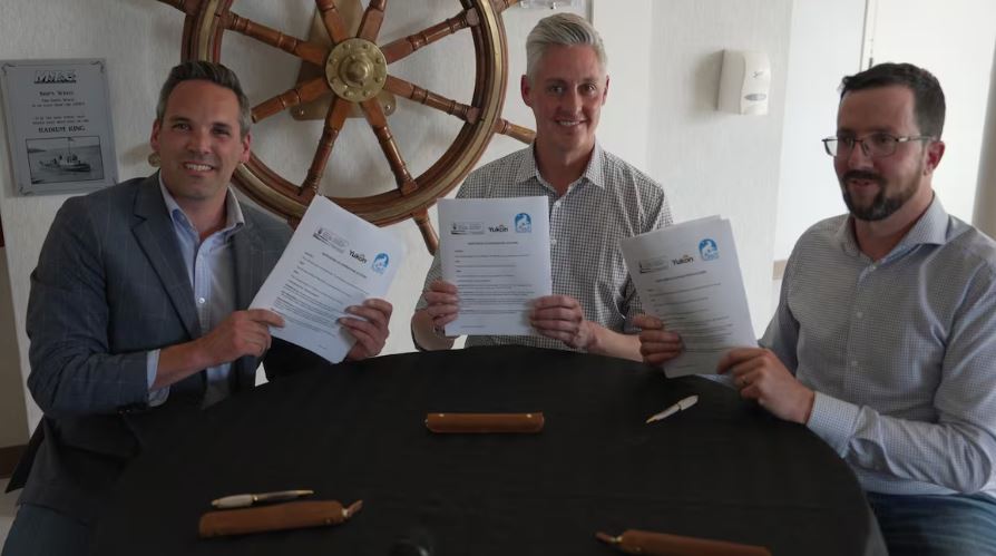 Three men holding up pieces of paper