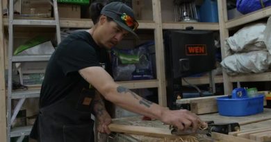 man cuts wood in workshop