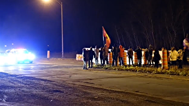 Seuls, une quarantaine de manifestants amérindiens mohawks ont bloqué pendant quelques heures l'accès au pont Honoré-Mercier sur la route 132 en direction de Montréal, mardi soir, sur leur réserve de Kahnawake, pour marquer leur opposition au déversement de huit milliards de litres d'eaux usées dans le fleuve Saint-Laurent, autorisé par la Ville de Montréal. « Sauvons notre fleuve », pouvait-on lire sur l'immense banderole qu'ils ont déployée près de la route, où ils ont aussi fait un feu et brandi des drapeaux mohawks. (Alain Béland - RC)