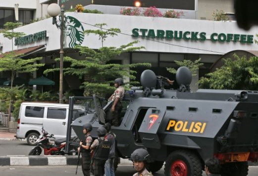 Un véhicule blindé de la police est stationné à l'extérieur d'un café Starbucks près du lieu d'une explosion à Jakarta . (Achmad Ibrahim / The Associated Press)