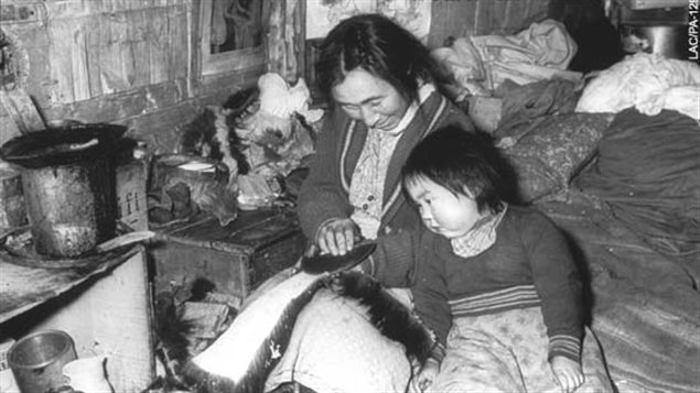 Femme expliquant la technique à un enfant : Inuits d’Ungava, Fort Harrison, Québec, 1947-48 (Richard Harrington) Crédit photo : virtualmuseum.ca