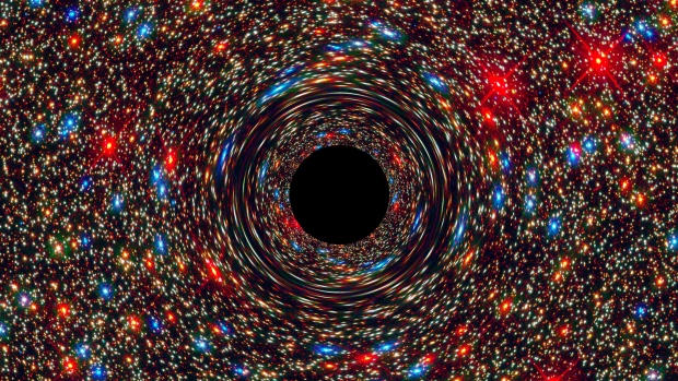 Cette image simulée par ordinateur montre un trou noir supermassif au cœur d'une galaxie. La région noire au centre représente la zone du trou noir où aucune lumière ne peut plus s'échapper de l'attraction gravitationnelle de l'objet massif. (NASA, ESA, et D. Coe, J. Anderson et R. van der Marel (STScI))