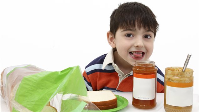 Un petit garçon s'apprête à manger du beurre d'arachide pour déjeuner. Photo Credit: iStock