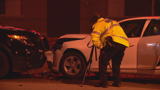 Un policier enquête à l'endroit où une voiture a foncé dans une barricade policière près du stade du Commonwealth à Edmonton. Photo : Radio-Canada