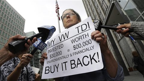 Une cliente proteste à San Francisco où Volkswagen est parvenu à un projet d’entente dans le scandale des véhicules dont le système antipollution avait été truqué. (avril 2016) © AP/Jeff Chiu RCI avec La Presse canadienne et Radio-Canada