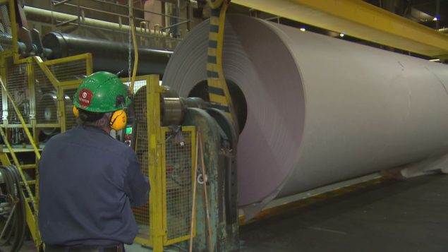 Un travailleur supervise la fabrication de papier journal. Photo : Radio-Canada/Benoît Jobin