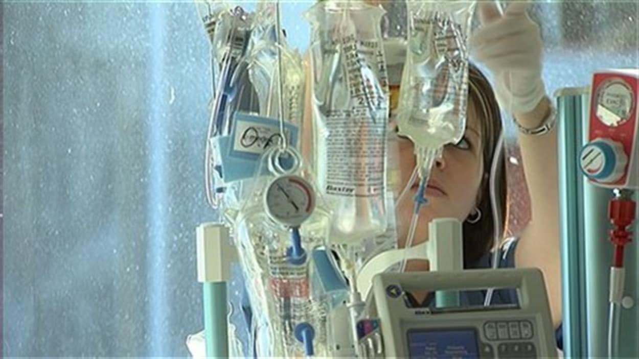 Une infirmière ajuste des solutés - Photo: Radio-Canada