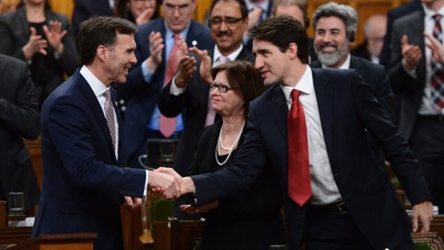 Le premier ministre Justin Trudeau, à droite, serre la main au ministre des Finances, Bill Morneau, après avoir déposé le budget fédéral à la Chambre des communes en 2017. (Sean Kilpatrick / Presse Canadienne)