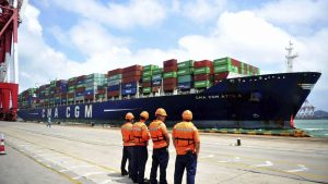 Des débardeurs regardent un bateau sur le quai d'un port chinois. Photo : Associated Press/Chinatopix via AP