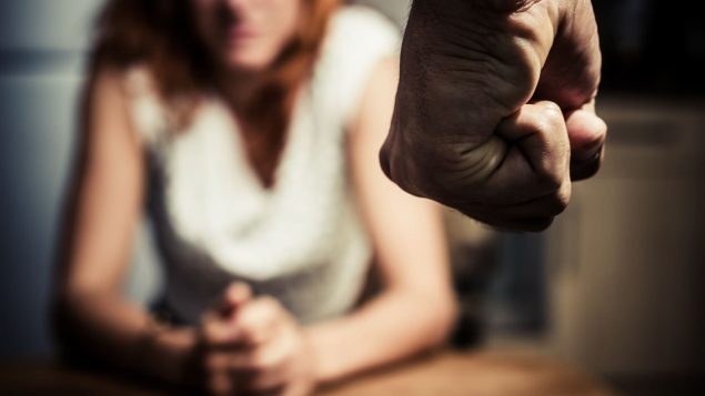 Le poing fermé d'un homme menace une femme.