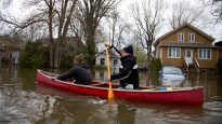 Taylor paddles Wentzel, a visitor from South Africa, out of flooded neighbourhood in Deux-Montagnes