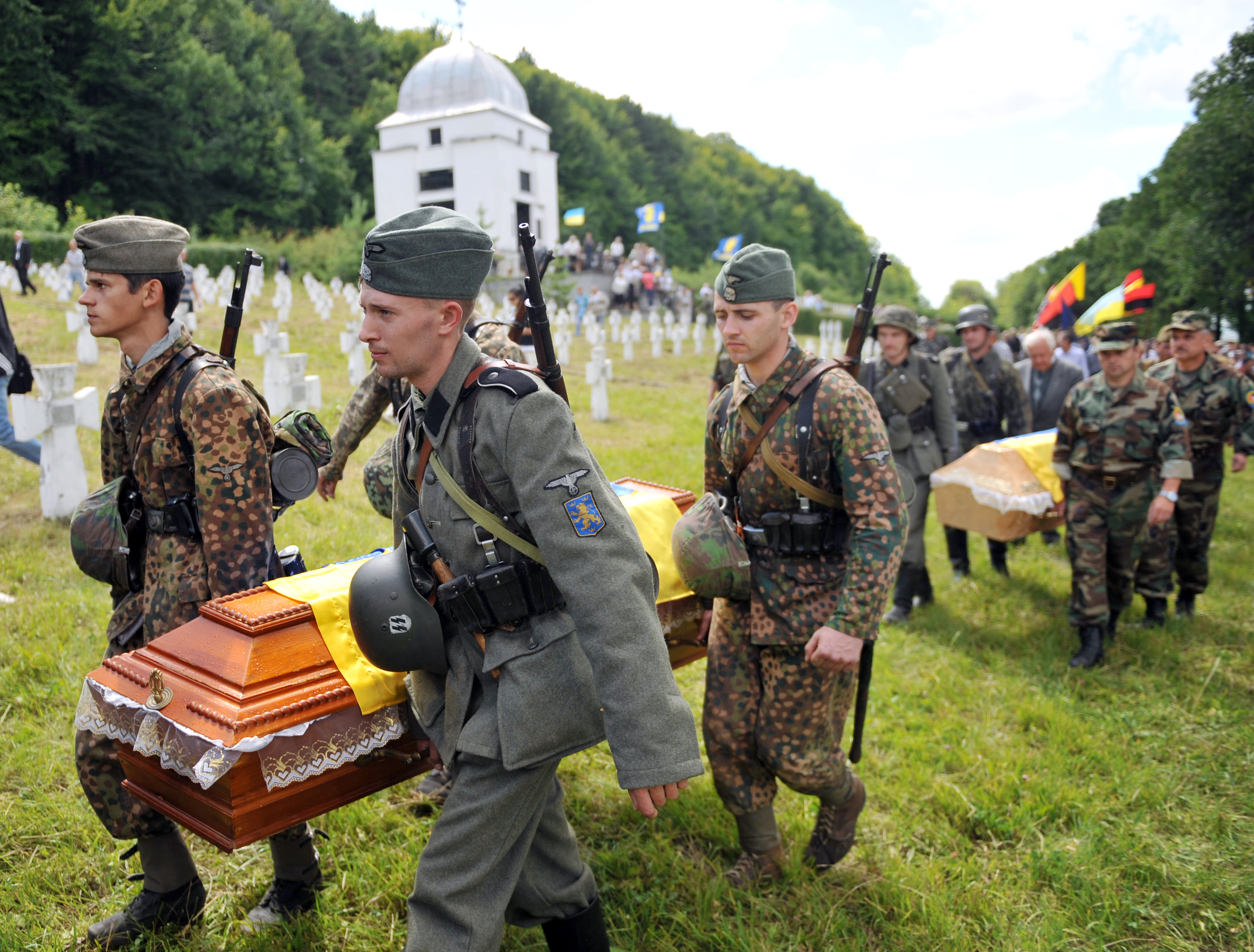Activists of the Ukrainian Pamiat (Memory) Searching Organization for victims of World War II, carry on July 21, 2013 the coffin with the remains of Soviet and Ukrainian soldiers of the "Galician" SS Division, during a reburial ceremony near the village of Chervone, some 70km west of Lviv. The "Galician" SS Division or 14th Grenadier Division of the Waffen SS 'Galician' was a World War II German military formation formed in 1943 (initially called the 14th SS-Volunteer Division "Galician") of volunteers from Galicia, western Ukraine, which later also incorporated Slovack, Czech and Dutch volunteers. AFP PHOTO / YURIY DYACHYSHYN (Photo credit should read YURIY DYACHYSHYN/AFP/Getty Images)