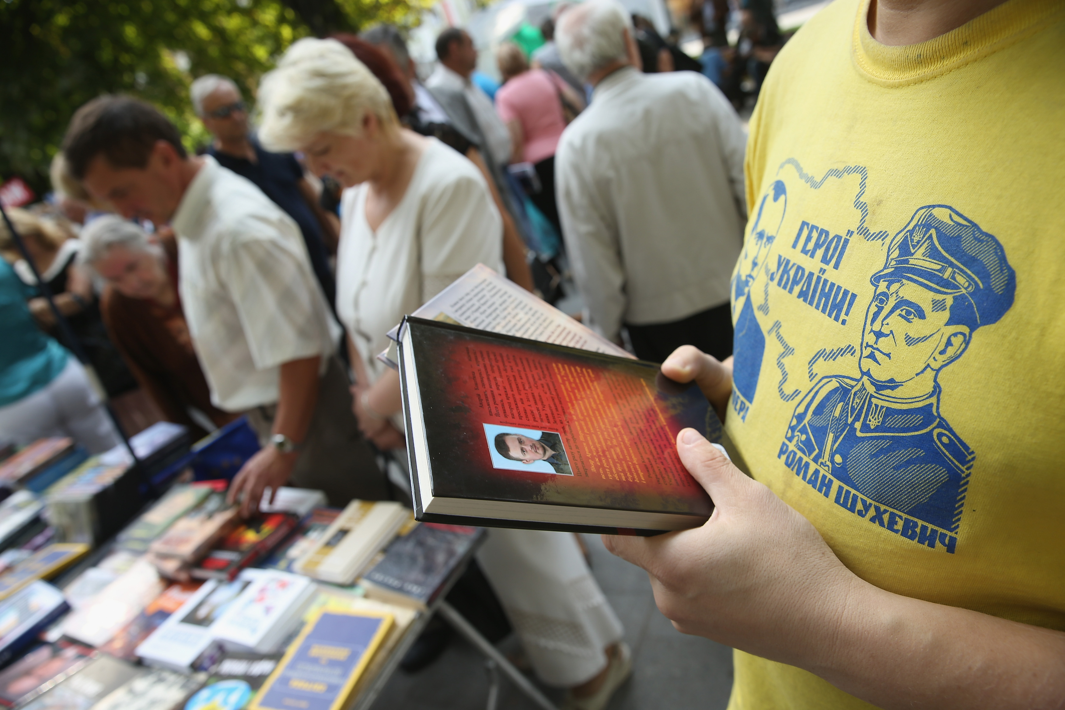 LVIV, UKRAINE - SEPTEMBER 14: A man at a stall selling "Ukrainian patriotic literature" wears a t-shirt showing historical Ukrainian nationalist militant figures Stepan Bandera and Roman Shukhevych under the slogan "Heroes of Ukraine!" on September 14, 2014 in Lviv, Ukraine. The ongoing war in eastern Ukraine between pro-Russian separatists and the Ukrainian army has influenced popular culture in Ukraine and encouraged Ukrainian nationalists. Many people in Ukraine doubt the current ceasefire overtures will lead to an end to the war and blame Russian President Vladimir Putin for stoking the violence. Stepan Bander and Roman Shukhevych led a violent uprising against Polish administratoin of western Ukraine in the 1920s and sided with the Nazis during World War II in their attempt to win Ukrainian independence. (Photo by Sean Gallup/Getty Images)