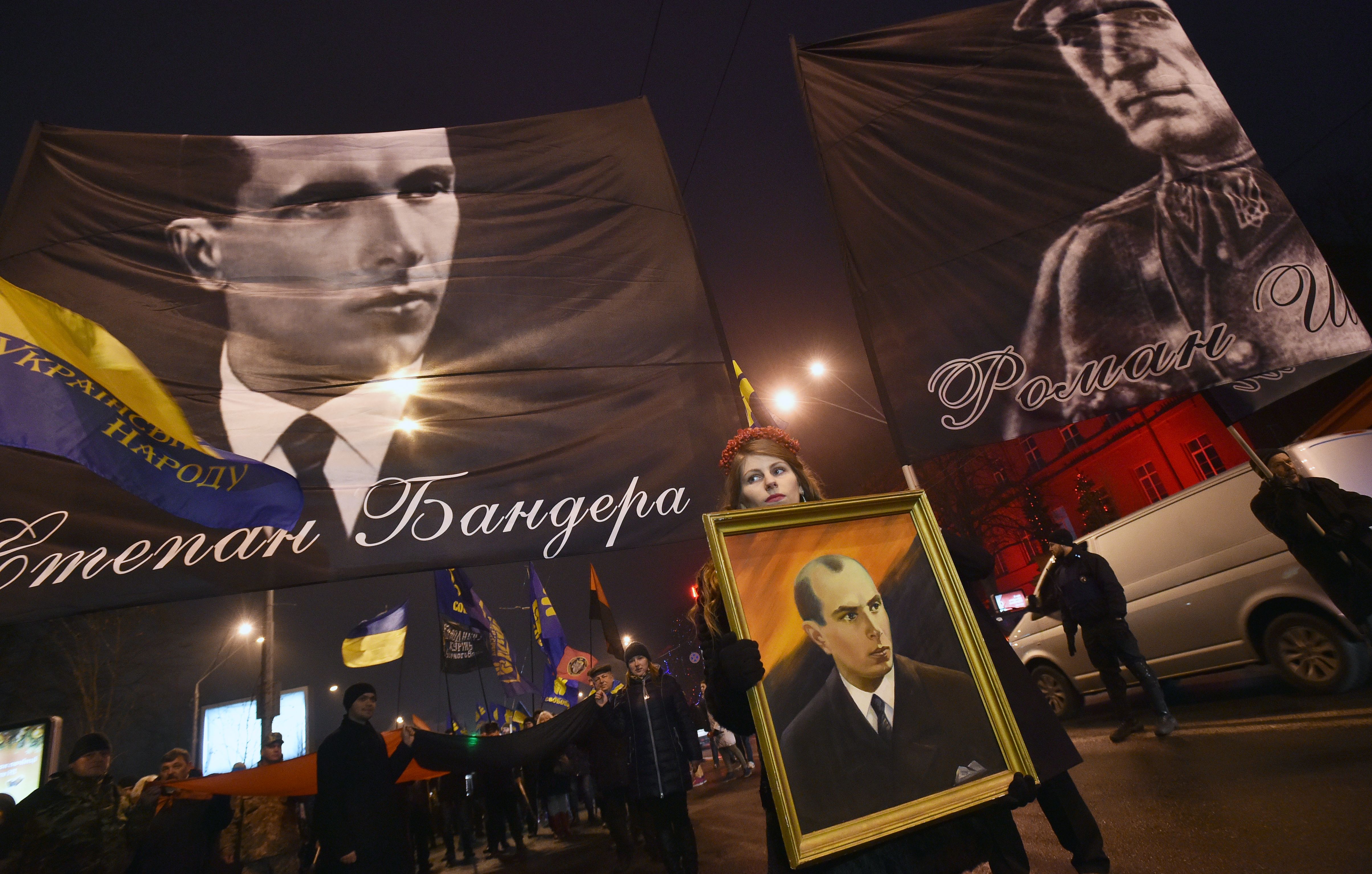 People hold flags picturing Ukrainian politician Stepan Bandera (L), one of the leaders of Ukrainian national movement and leader of the Organisation of Ukrainian Nationalists (OUN) and his ally Roman Shukhevych (R) during a march in Kiev on January 1, 2017, to mark the 108th anniversary of the birth of the Ukranian politician. / AFP / GENYA SAVILOV (Photo credit should read GENYA SAVILOV/AFP/Getty Images)