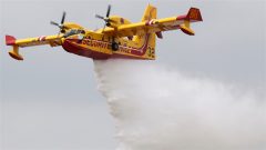 Un avion-amphibie canadair largue de l'eau pour combattre un incendie.
