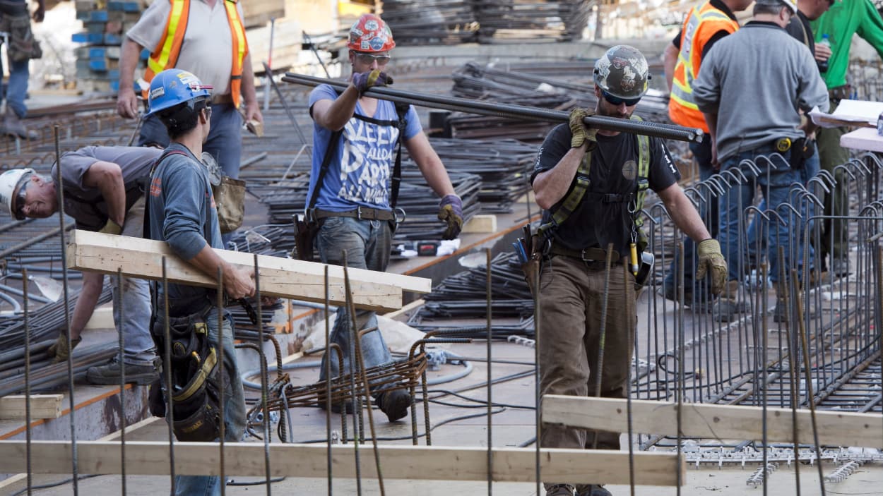 Des hommes transportent du matériel sur un chantier