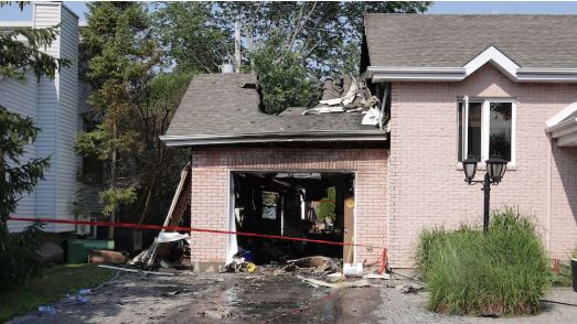 L’explosion de la voiture électrique avait soufflé la porte d’un garage résidentiel et causé des dégâts importants vendredi après-midi à L’Île-Bizard, dans l’ouest de Montréal - Radio Canada / Mathieu Daniel Wagner