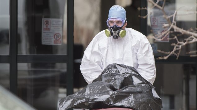 Transfert du corps d'un résident du CHSLD Herron par un ambulancier - 11 avril 2020 - Photo : La Presse canadienne / Graham Hughes