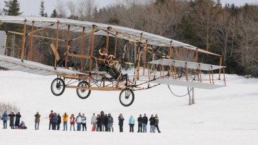 A replica of the Silver Dart soars into the sky on the day of the 100th anniversary of the first airplane flight in Canada. (CBC News)