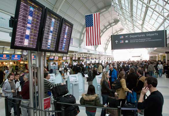 Passengers bound for the U.S. wait to go through customs at Toronto International Airport.  (Frank Gunn / Canadian Press) 