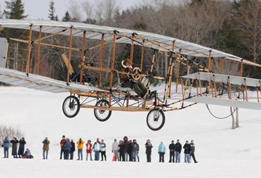 Une réplique du Silver Dart s’élance dans le ciel le jour du 100e anniversaire du premier vol d’avion au Canada. (CBC News)