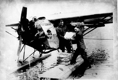 Un aviateur donne du courrier à son confrère Fred Stevenson, en 1927. (Archives de l’aéroport international de Winnipeg)