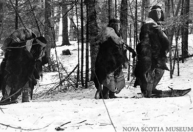 Des Indiens micmacs se promènent dans une forêt, l’hiver, dans l’est du Canada. Cette photo a été prise en 1981, lors du tournage d’un documentaire historique de la télévision de CBC. (Musée de la Nouvelle-Écosse)