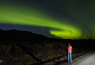 Une femme contemple une aurore boréale pendant une belle nuit du mois d’août 2010. (M. Scott Moon/Canadian)